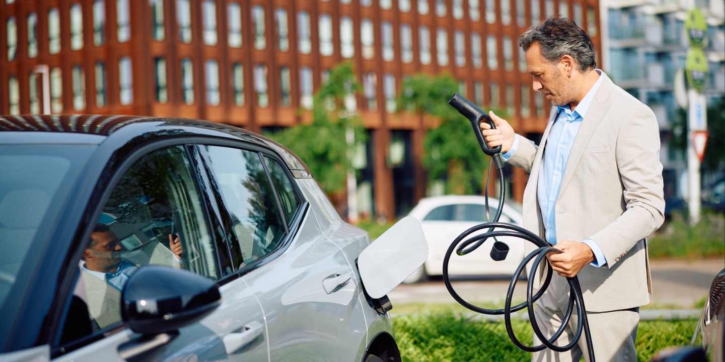 A man charging his EV at a Portuguese CPO that moves from MOBI.E to RJME