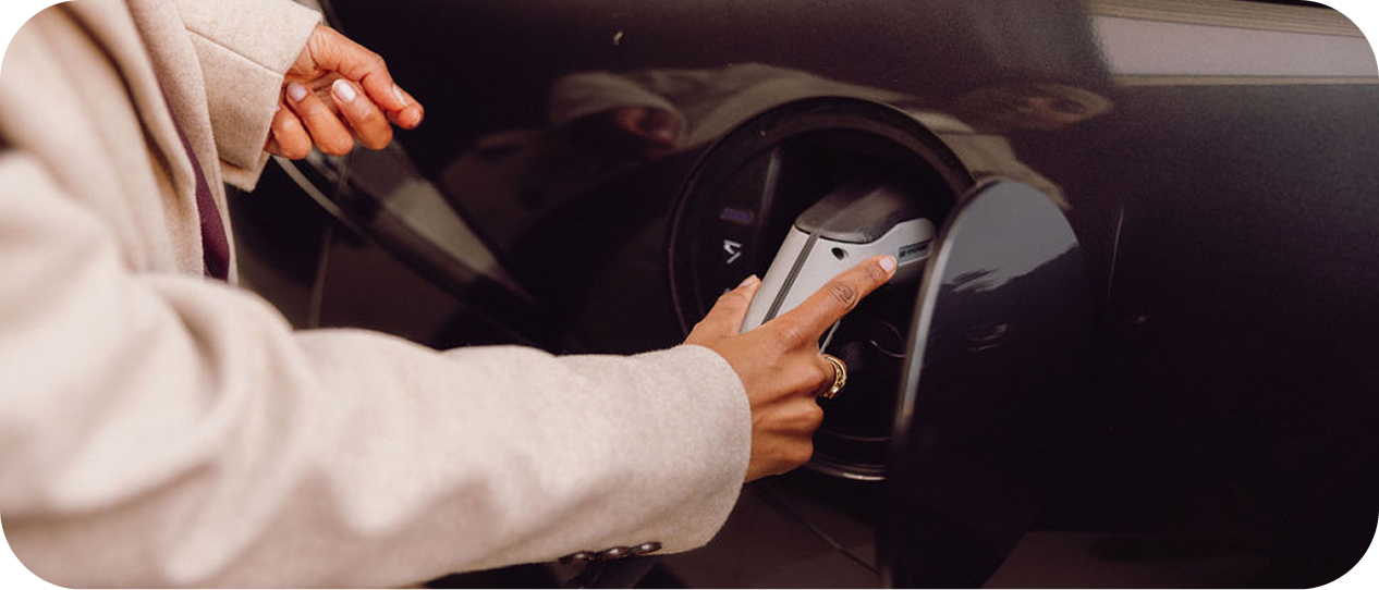 Woman connecting her EV to the charge station via OCPP and OCPI protocols
