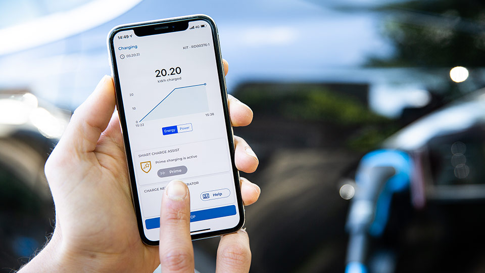 hand holding smart phone showing current status of EV charging in app